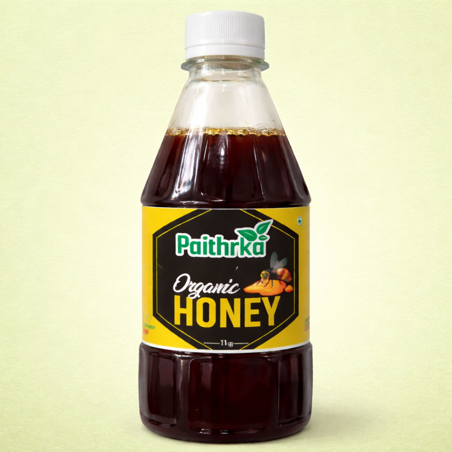 Paithrka Organic Honey 500gm in a clear plastic bottle with yellow and black label and a bee illustration
